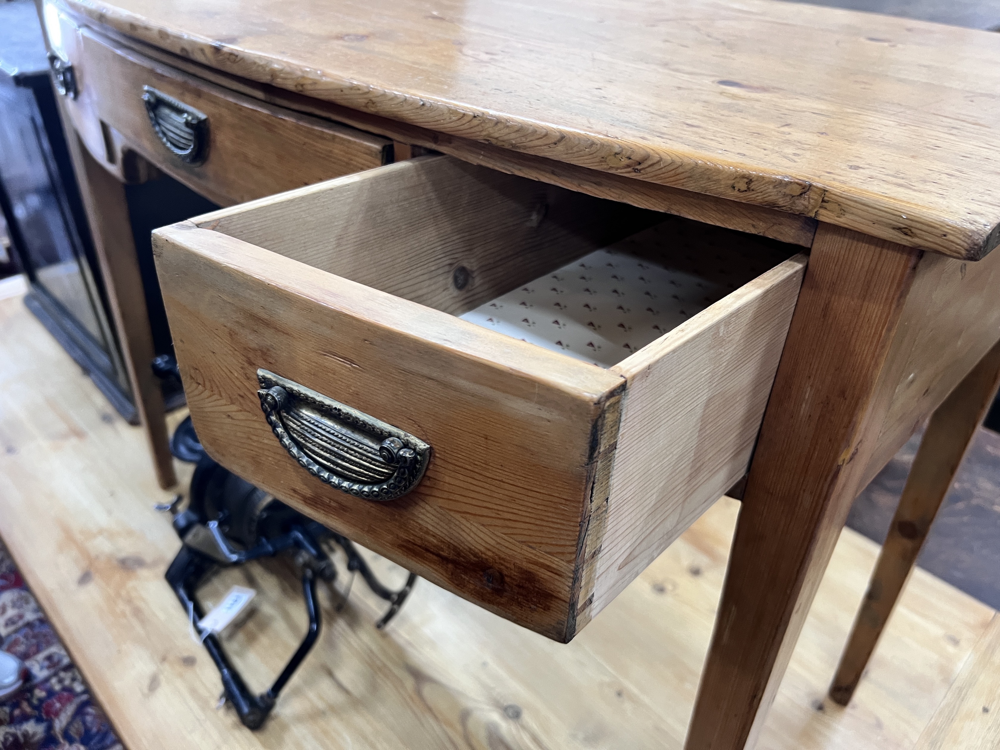 An early 19th century pine bow front three drawer side table, width 97cm, depth 50cm, height 73cm